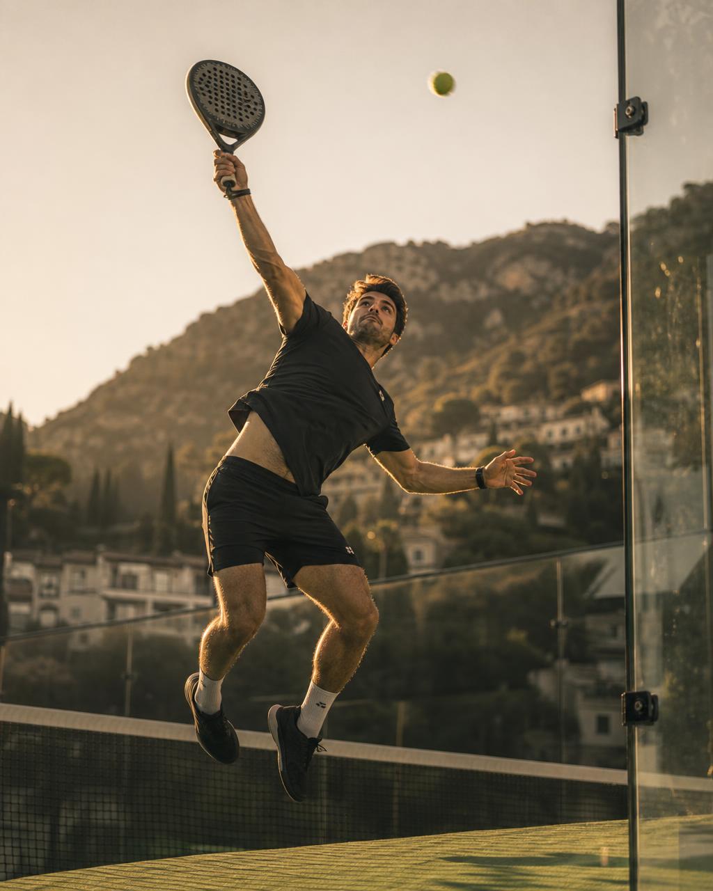 Padel player reaching for an overhead shot at golden hour